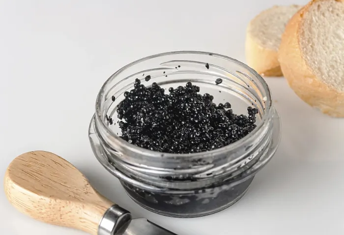 Framed Print : Halibut caviar in a glass jar on a white background