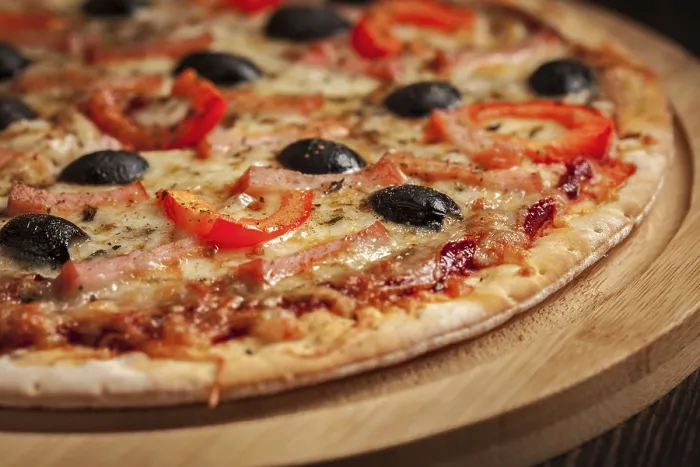Framed Print : Ham pizza with (capsicum) and olives on wooden board on table close up Framed Print : Ham pizza with (capsicum) and olives on wooden board on table close up
