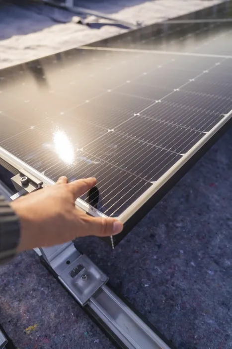 Framed Print : A hand adjusts a solar panel on a roof in the sunlight