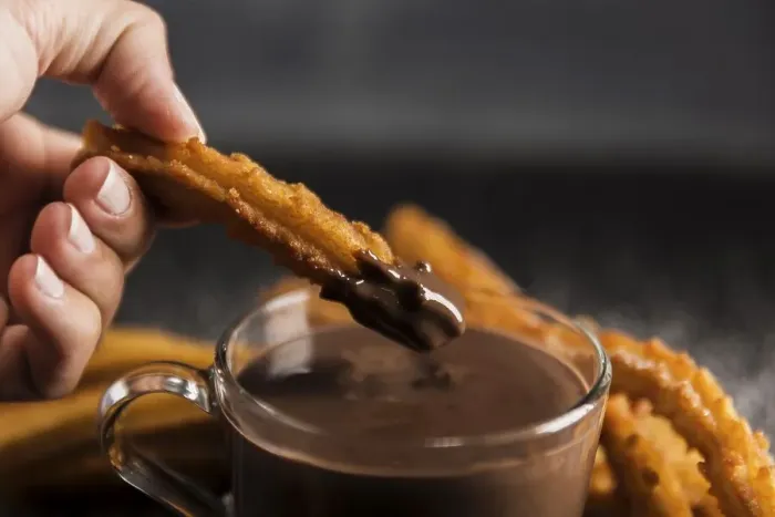 Framed Print : Hand dipping fried churros chocolate Framed Print : Hand dipping fried churros chocolate