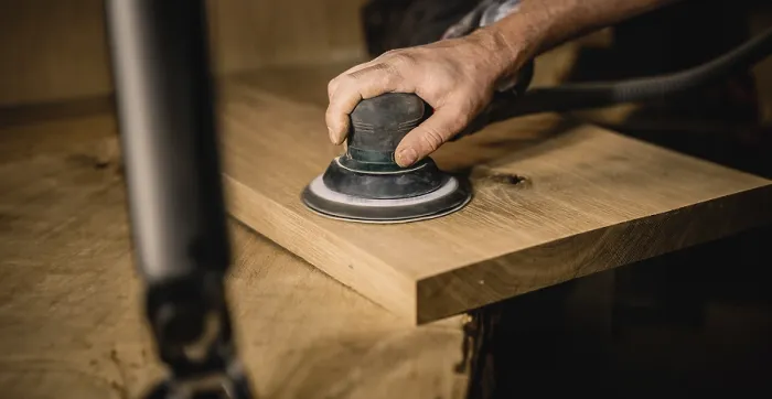 Framed Print : Hand sanding a wooden plank in a workshop