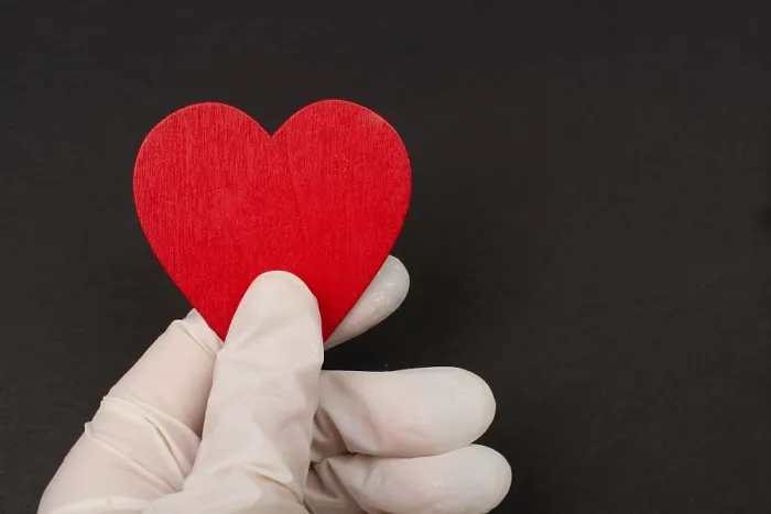 Framed Print : Hand in sterile glove hold a heart Framed Print : Hand in sterile glove hold a heart