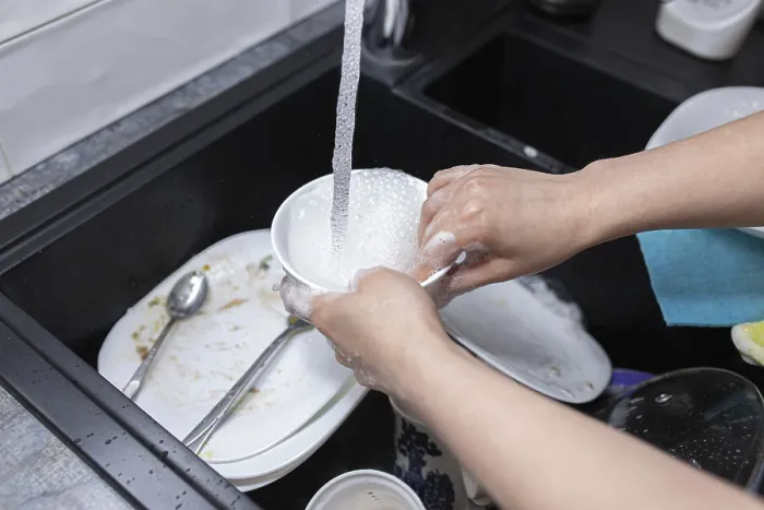 Framed Print : Hands cleaning a bowl under running water in a kitchen sink Framed Print : Hands cleaning a bowl under running water in a kitchen sink