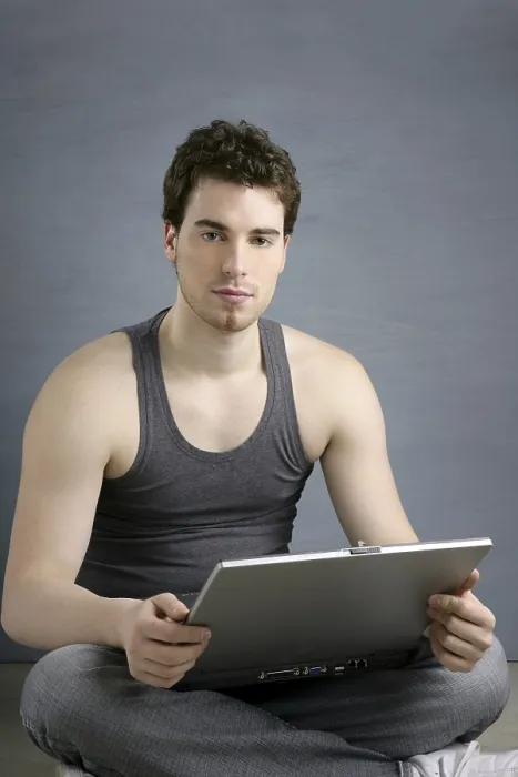 Framed Print : Handsome student young man sit working on laptop over gray background