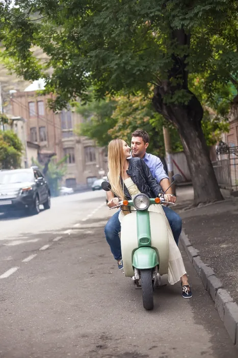 Framed Print : Happy young couple by a vintage scooter on the street