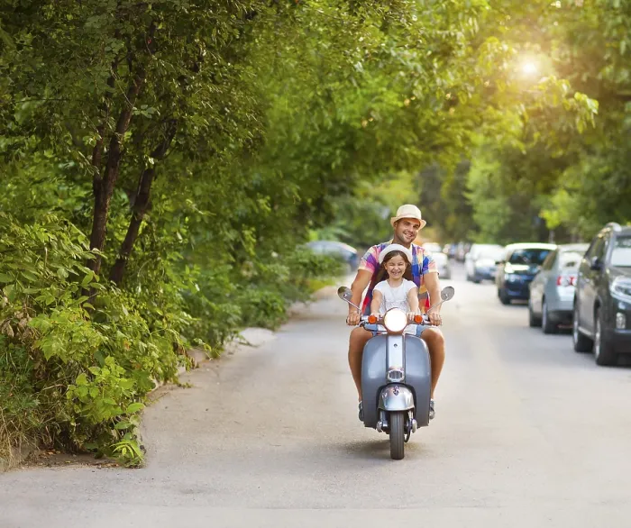 Framed Print : Happy young father and little daughter riding a vintage scooter in the street wearing hats