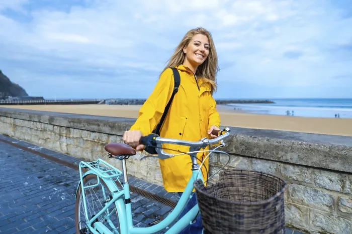 Framed Print : Happy young woman walking with her bicycle on the boardwalk by the beach