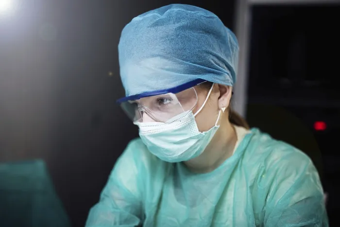 Framed Print : A healthcare worker in protective gear focused on a task Framed Print : A healthcare worker in protective gear focused on a task