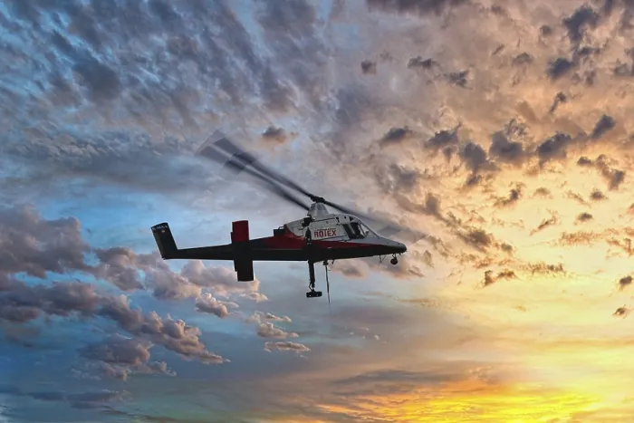 Framed Print : A helicopter flies in front of a colourful sunset with dramatic cloud formations