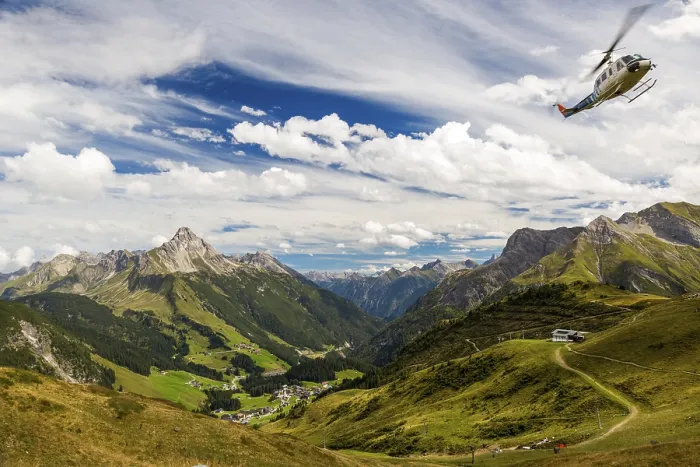 Framed Print : A helicopter flies over a mountainous landscape with blue skies and clouds