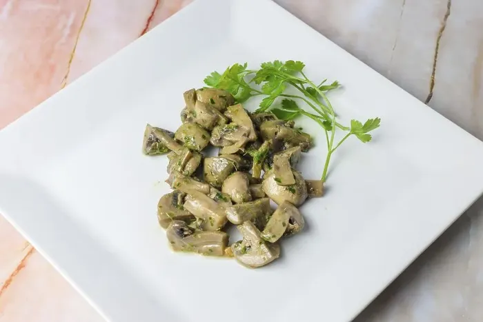 Framed Print : Herb-marinated mushrooms with parsley on a square white plate
