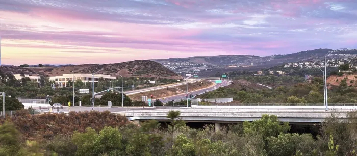 Framed Print : Highway in Irvine, California, at sunset with mountain range in the distance in summer
