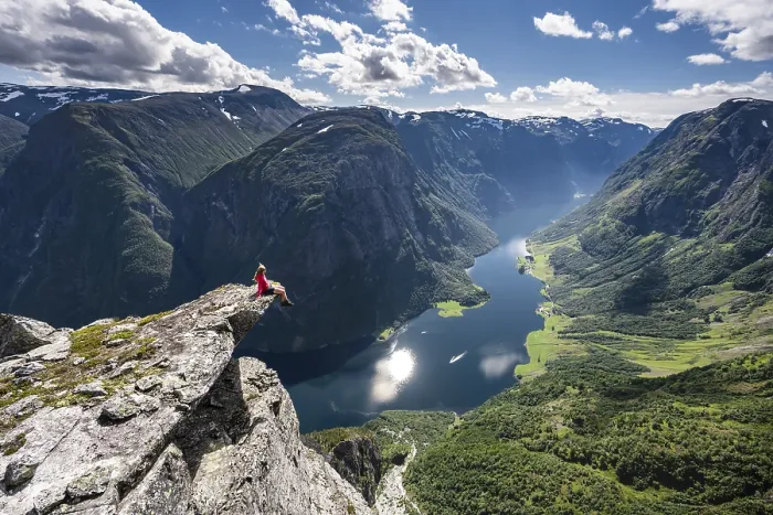 Framed Print : Hiker sitting on rock, view from the top of Breiskrednosi