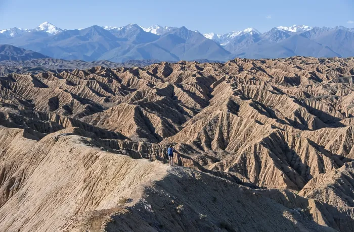 Framed Print : Hiker walking along a canyon, Tian Shan mountains in the background