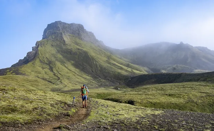 Framed Print : Hikers on trail through moss-covered mountain landscape
