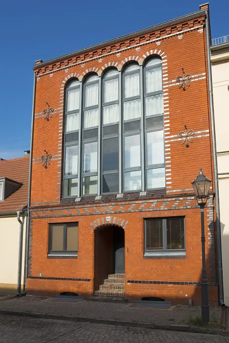 Framed Print : Historic building with brick facade and large windows under a clear sky