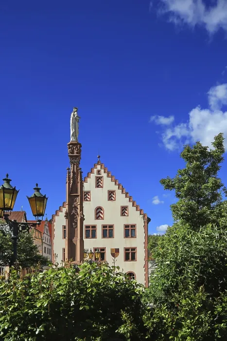 Framed Print : Historic building with statue and column surrounded by trees under blue sky