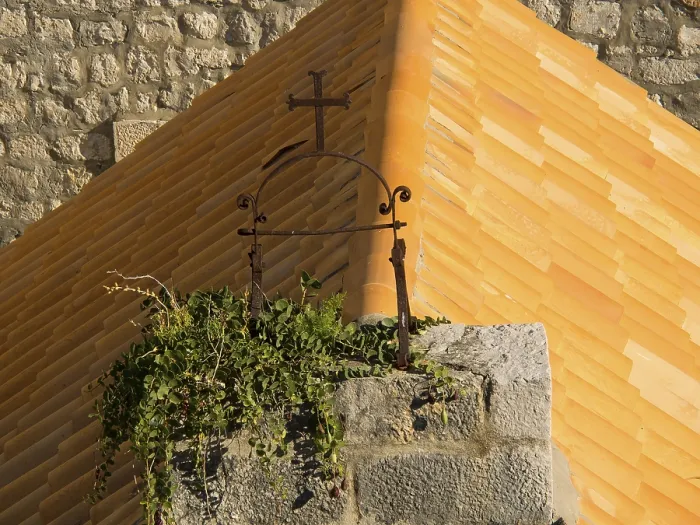 Framed Print : Historic cross on an overgrown roof in a medieval setting