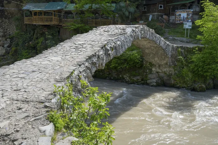 Framed Print : Historic stone bridge crosses bubbling river in forest