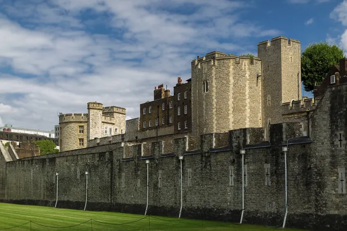 Framed Print : Historic stone structure under a vibrant blue sky with clouds at The Tower of London