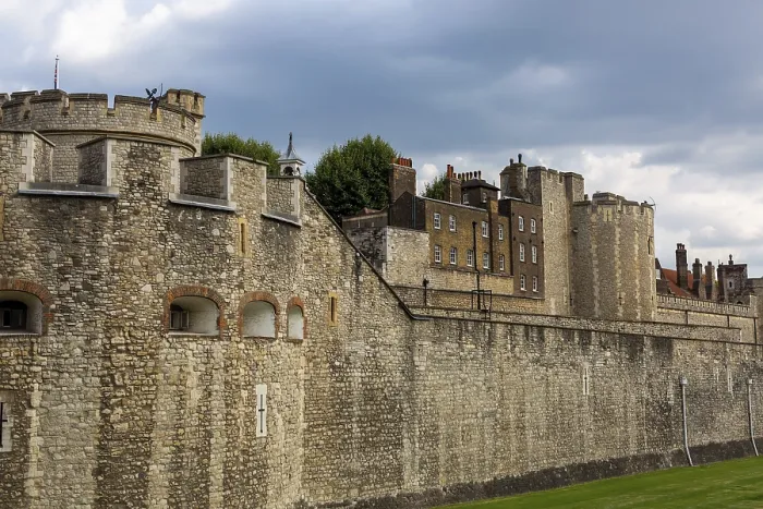 Framed Print : Historic stone wall and towers under a cloudy sky at The Tower of London