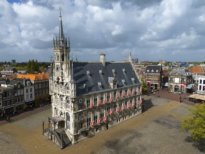 Framed Print : Historic town hall on an empty market square with gothic architecture and cloudy sky