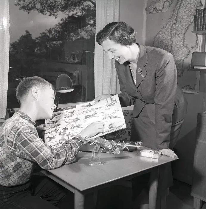 Framed Print : Hobby in the 1950s. A boy is sitting at a table with a plastic model of an American bomb aircraft B29