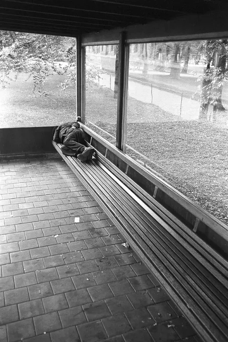 Framed Print : Homeless in the 1950s. A man is pictured sleeping on the bench at a bus stop