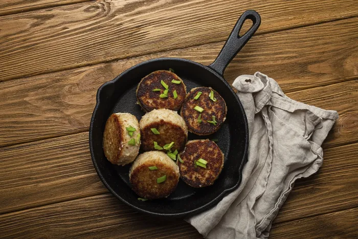 Framed Print : Homemade cutlets from fish, chicken or meat on black cast iron frying pan skillet on rustic wooden table