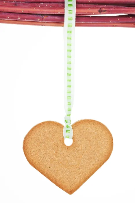 Framed Print : Homemade gingerbread heart hanging from branches isolated over white background