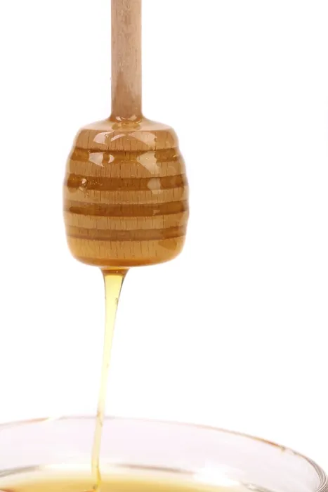 Framed Print : Honey dripping from wooden stick isolated on white background Framed Print : Honey dripping from wooden stick isolated on white background