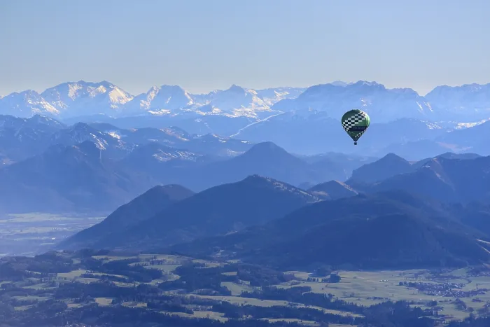 Framed Print : Hot air balloon flying in front of a mountain landscape