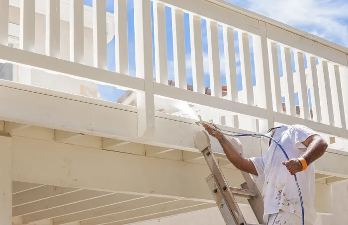 Framed Print : House painter wearing facial protection spray painting A deck of A home Framed Print : House painter wearing facial protection spray painting A deck of A home
