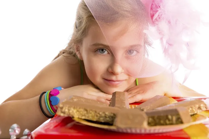 Framed Print : Hungry gesture blond kid girl in party with chocolates at birthday