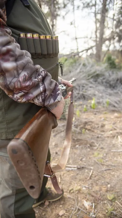 Framed Print : Hunter gripping a shotgun and wearing an ammunition belt while navigating through the dense forest Framed Print : Hunter gripping a shotgun and wearing an ammunition belt while navigating through the dense forest