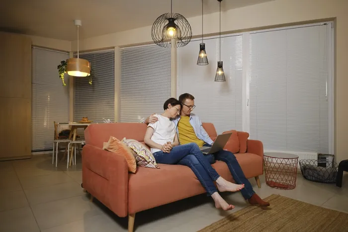 Framed Print : A husband embraces his wife while sitting on a couch in a modern living room Framed Print : A husband embraces his wife while sitting on a couch in a modern living room