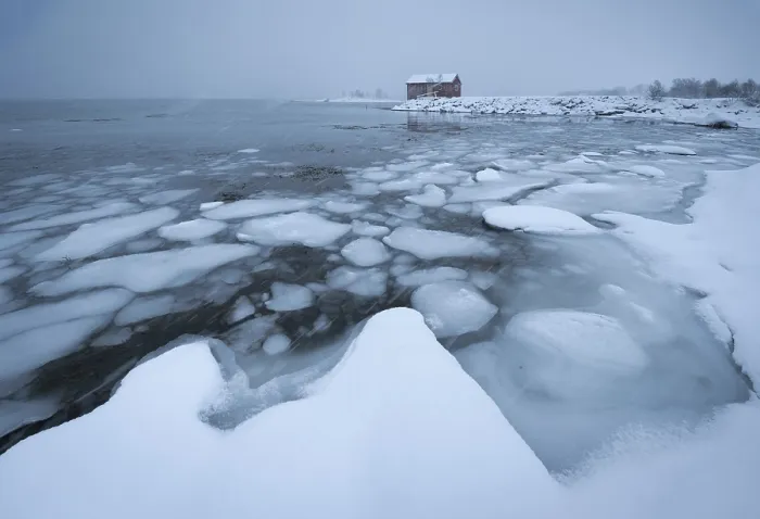Framed Print : Ice floes at the frozen fjord with thick snowfall and dark cloud atmosphere
