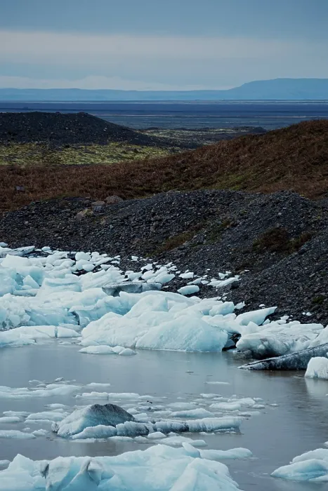 Framed Print : Ice patches on rocky ground leading to a distant horizon under an overcast sky