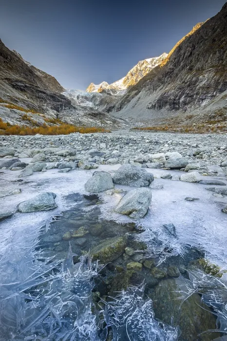 Framed Print : Ice structures on mountain stream with autumnal larches and mountain panorama