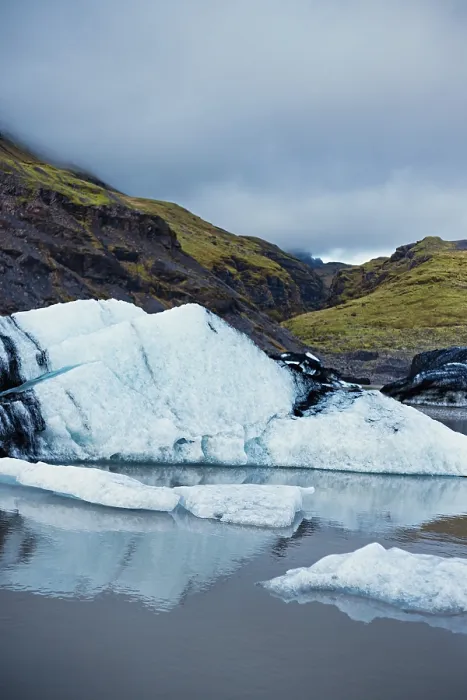 Framed Print : Ice surfaces against mountainous terrain and a cloudy sky