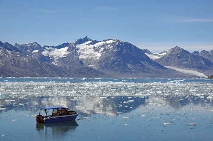 Framed Print : Icebergs reflected in a fjord, small blue boat