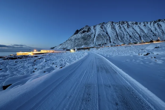 Framed Print : Iced snow road, illuminated village in twilight