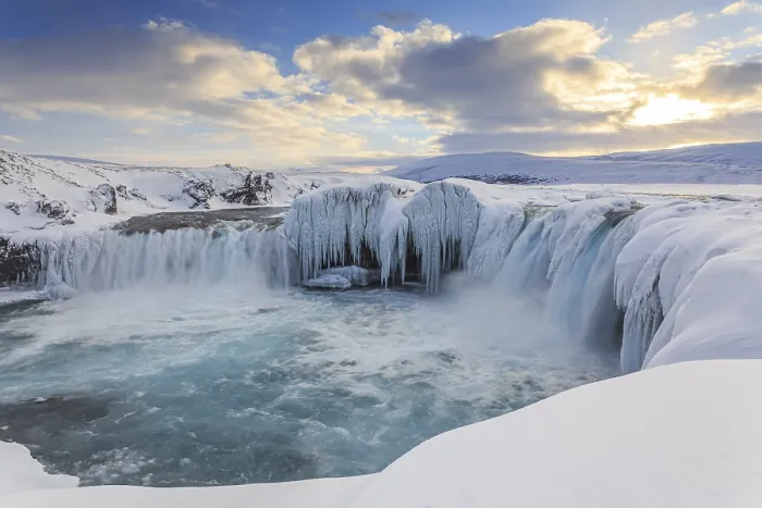 Framed Print : Icy waterfall and rapids in front of a mountain landscape