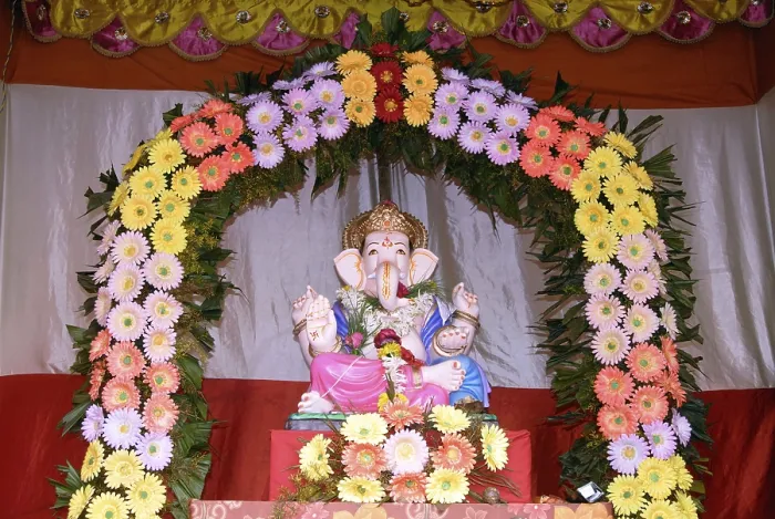 Framed Print : Idol of Lord Ganesh kept in gaily decorated frame of colourful flowers elephant headed god