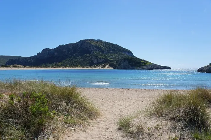 Framed Print : An idyllic beach with clear blue water and a mountain in the background on a sunny day Framed Print : An idyllic beach with clear blue water and a mountain in the background on a sunny day