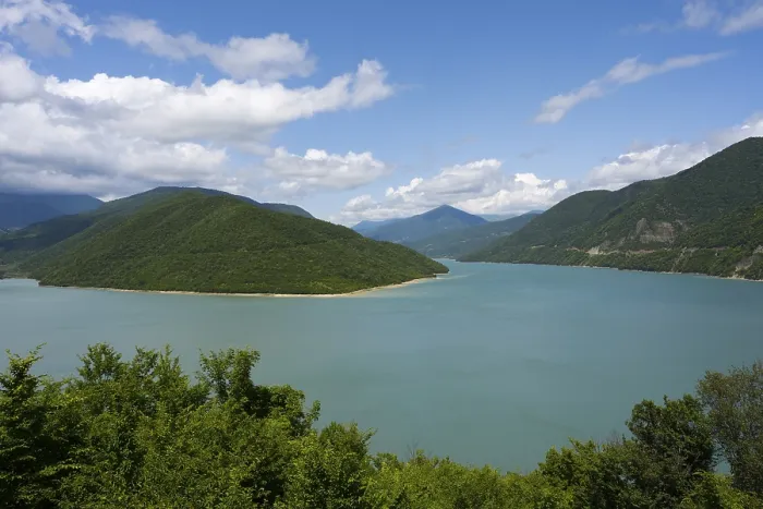 Framed Print : Idyllic landscape with a large lake surrounded by green mountains under a blue sky with clouds