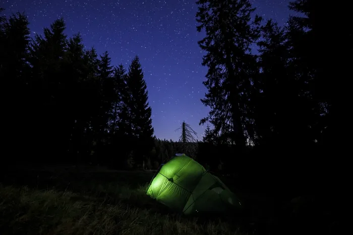 Framed Print : Illuminated green tent at the edge of the forest