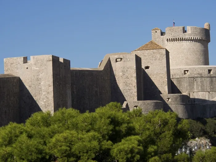 Framed Print : An imposing medieval fortress with high walls and towers rises into the blue sky