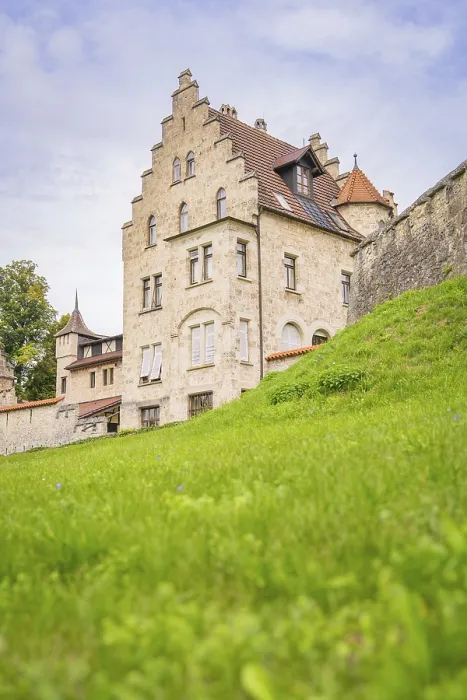 Framed Print : Impressive historic building with gabled roof and green meadow