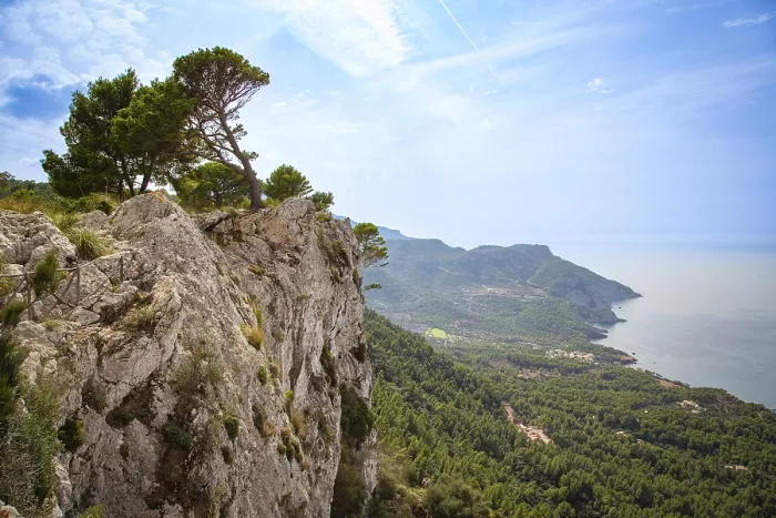 Framed Print : An impressive panorama of a rock face with trees above a coastline and the blue sea